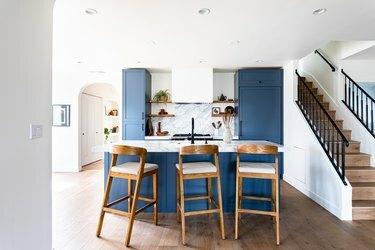 keittiö, jossa siniset kaapit ja marmorinen takalevy