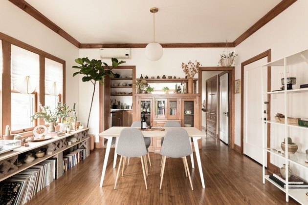 casa com design ecológico e sala de jantar minimalista com mesa de madeira, luminária e cadeiras Eames cinza