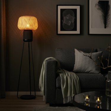 IKEA zvučnik za podnu lampu u zamračenoj dnevnoj sobi sa svjetlom lampe koje daje blagi sjaj.