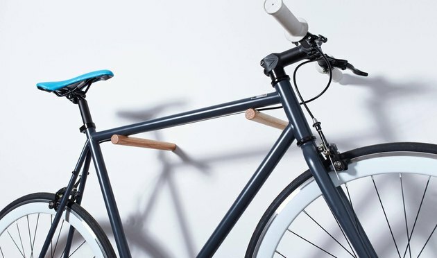 armazenamento de bicicletas usando pinos de madeira montados na parede