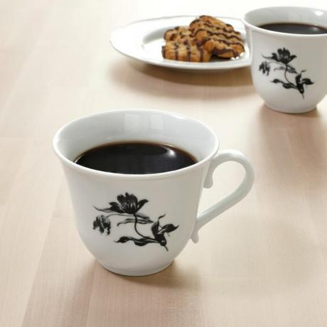 duas canecas com um prato de biscoitos no fundo
