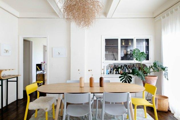 étkező helyiség faasztallal, szürke és sárga székekkel