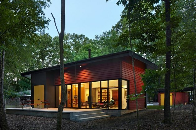 casa modular vermelha em uma floresta com design residencial ecologicamente correto