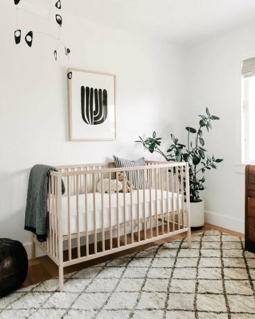 witte minimalistische kinderkamer inrichting met plant in de hoek