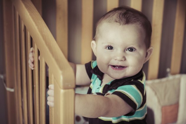 Bébé heureux debout dans son berceau