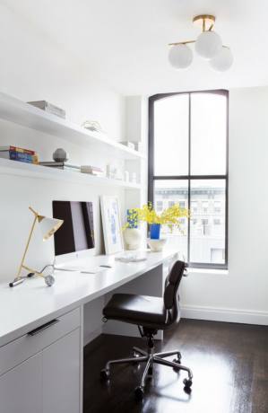 Idéias de organização de home office com mesa branca, cadeira preta, abajur de latão, prateleiras brancas, globo de luz branca.