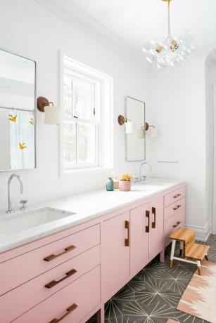 idea bagno per bambini con vanità rosa e pavimento in cemento