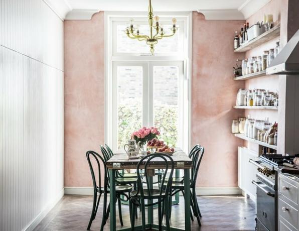 roze eetkamer in landelijke keuken met groene stoelen en tafel