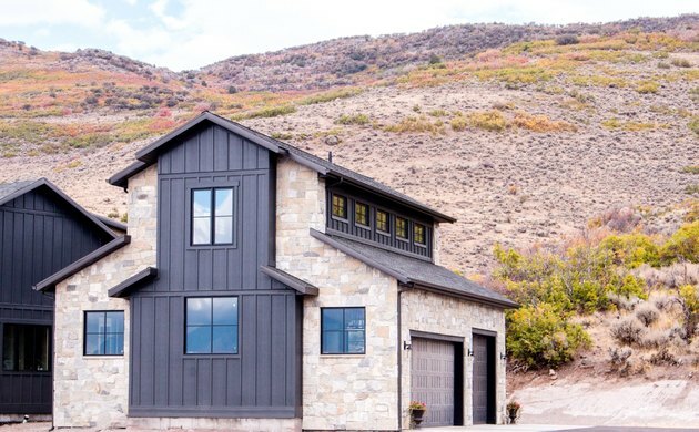 Exterior de casa contemporânea com construção em pedra e revestimento em paisagem montanhosa