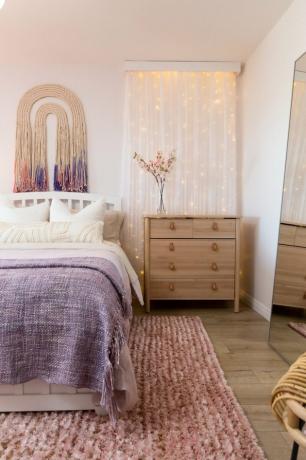 غرفة نوم وردية وأرجوانية مع أضواء خرافية على الحائط ونسيج حائط حديث