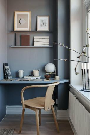 home office azul claro em um canto com prateleiras embutidas
