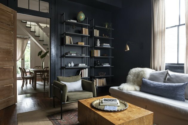 ألوان محايدة سوداء في غرفة المعيشة مع أريكة رمادية وكرسي لهجة خضراء