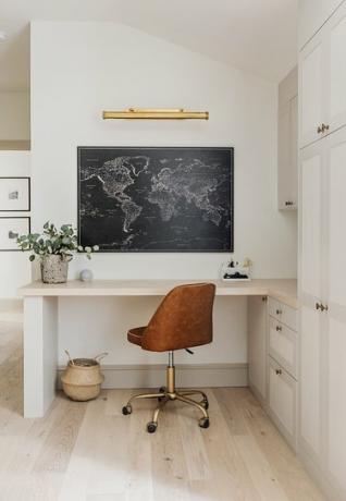 oficina en casa de esquina con escritorio incorporado y silla de oficina de cuero