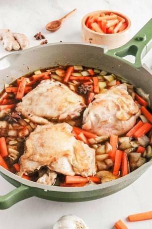 Pollo, verduras y caldo en una sartén