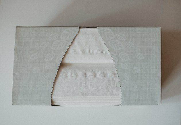 grå rektangulær Kleenex vevskasse dekket med bladtrykk