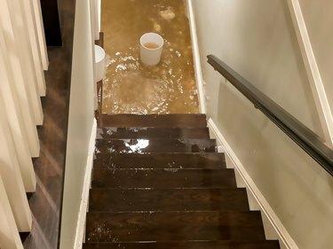 बाढ़ का पानी सीढ़ी से नीचे घर के बेसमेंट में बह रहा है