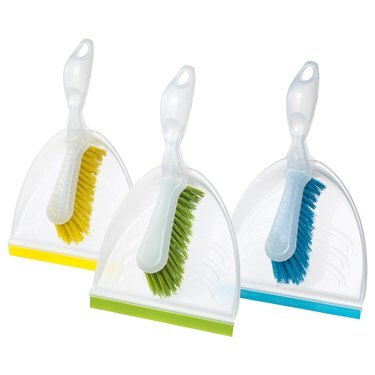 três panelas de poeira e pincéis em amarelo, verde e azul
