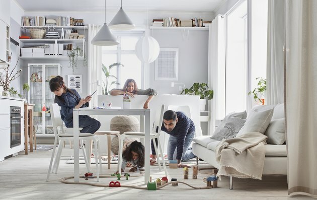 família na sala com mesa e trem