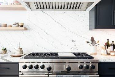 Kuhinjska peć s bijelim granitnim pločama i drvenim policama