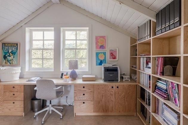 Como organizar uma estante em sala com mesa, teto arqueado branco, janelas, cadeira de mesa, abajur, livros, arte.