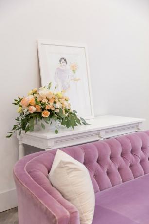 sofá tufado rosa com mesa branca e obras de arte emolduradas
