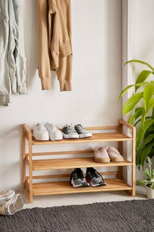 Prateleira de bambu para armazenamento de sapatos na entrada com alguns pares de sapatos na entrada