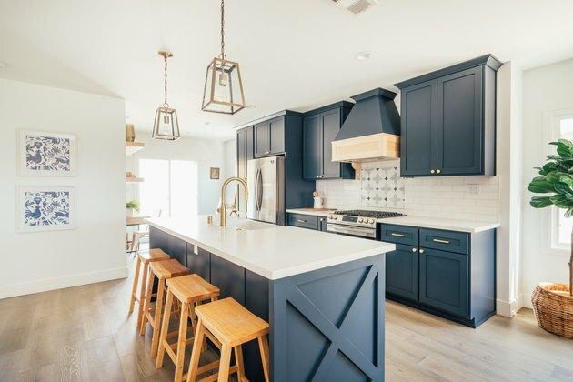 Cozinha de quinta moderna em azul e branco com luzes pendentes de latão e vidro