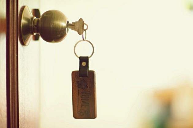 Namo raktas su namų raktų įvedimu rakto skylėje, turto koncepcija