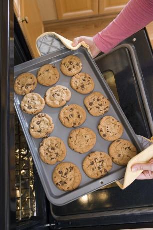 Donna che rimuove i biscotti dal forno