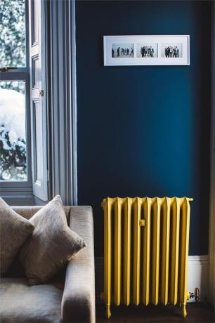 woonkamer met gele radiator en donkerblauwe muren