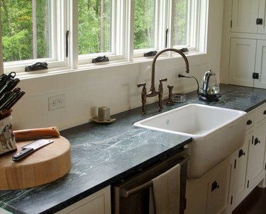 Comptoirs de cuisine en pierre ollaire avec évier de ferme et armoires blanches