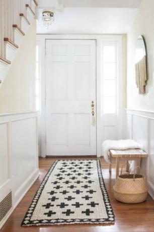 baltas prieškambaris su rankomis dažytu džiuto kilimu