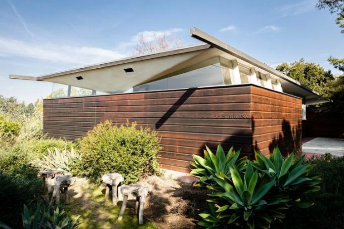 Esterno della casa di metà del secolo di John Lautner con recinzioni in legno e piante autoctone