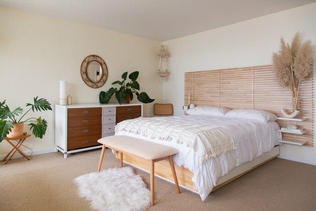 spazio camera da letto con testiera in legno e biancheria da letto bianca