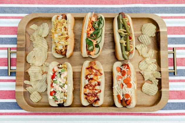 Šest gurmanskih hot-dogova posađenih na drvenom poslužavniku s pomfritom od krumpira
