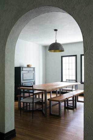 idea di illuminazione della sala da pranzo con tavolo in legno e lampada a sospensione in metallo