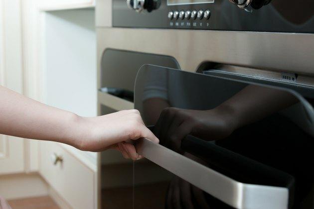 mano aperta porta del forno in cucina moderna