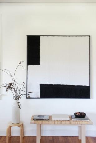 Arte de parede de cisalhamento em preto e branco com bancada, banquinho e planta
