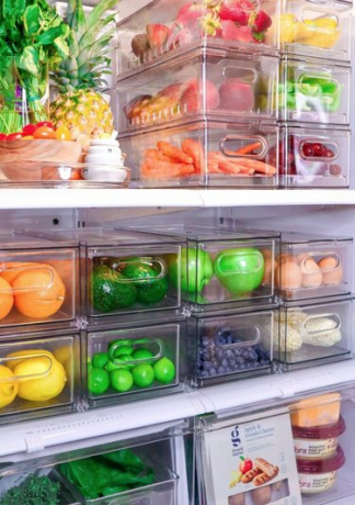 Geladeira organizada com recipientes plásticos transparentes.