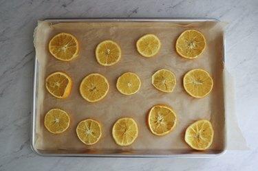 Appelsinskiver på toppen av bakepapirkledd stekebrett