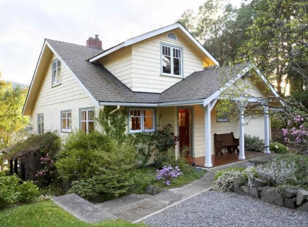 Exterior da casa estilo chalé com jardim na frente