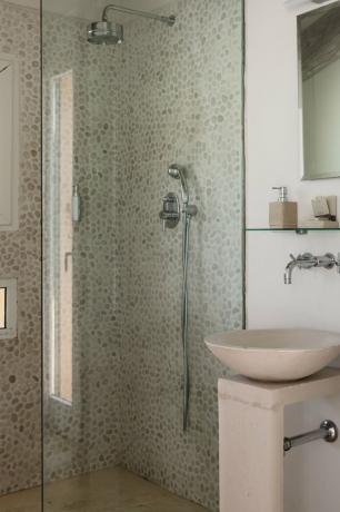 stein kar vask med sølv veggmontert kran, glasshylle, rektangulært speil, glass dusj dør, flerfarget dusj vegg flis