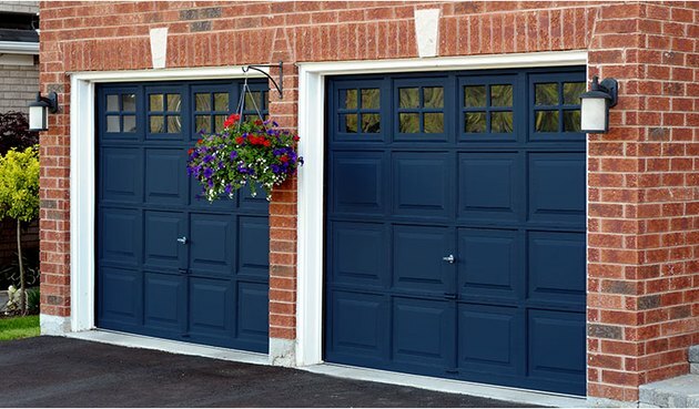 Portas de garagem em azul marinho em casa de tijolos