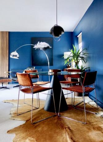 Apartamento contemporâneo com paredes azuis e sala de jantar