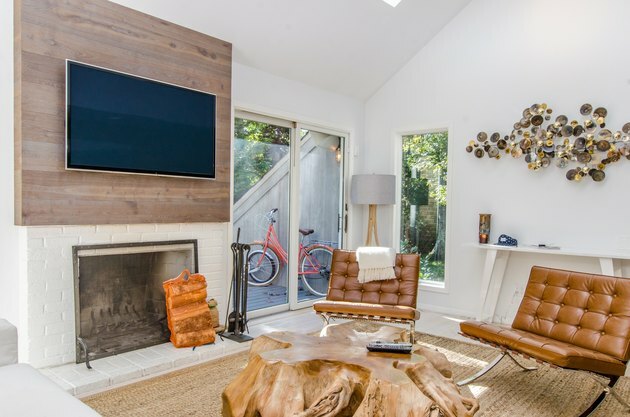 Familiekamer met open haard en tv-indeling gecombineerd met honingleren stoelen.