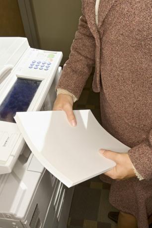 Carta della tenuta della donna accanto alla macchina della copia