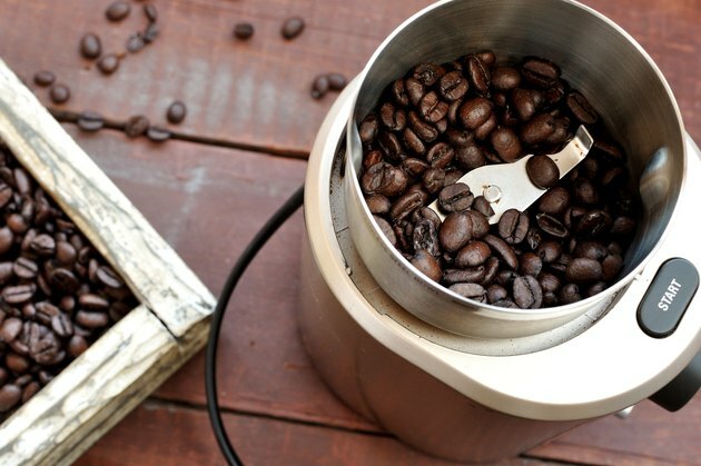 Molinillo de café eléctrico con granos de café tostado.