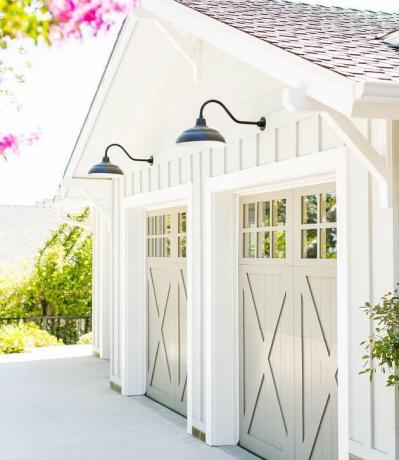 Portas de garagem de celeiro creme com exterior branco e luzes pretas