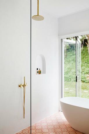 chuveiro minimalista branco com ferragens de latão e ladrilhos rosa