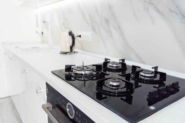 תנור גז שחור-הייטק מודרני עם לוח חיישן בפנים הבהירות של המטבח